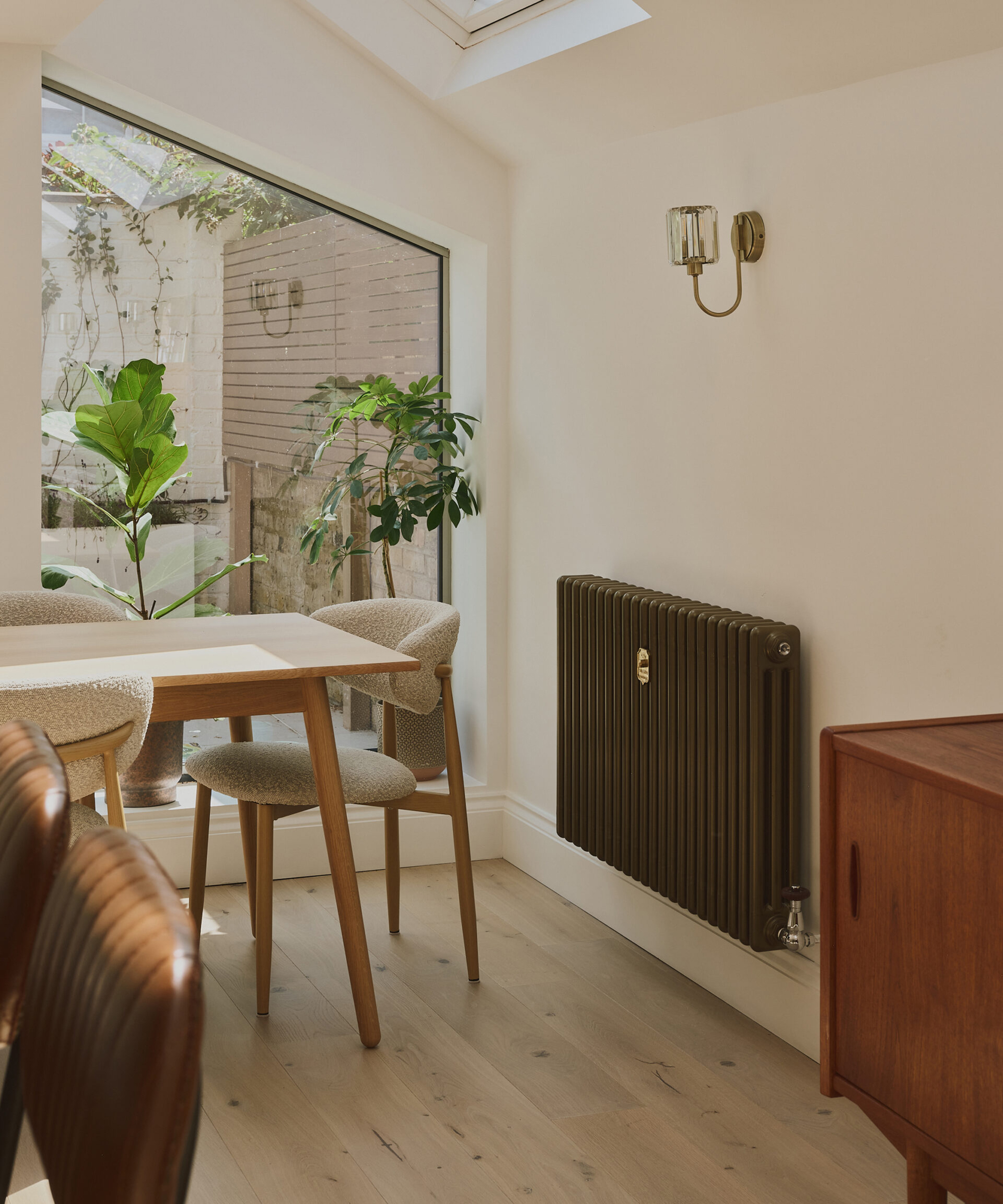 modern side return kitchen extension with black column radiator and pale engineered wooden flooring