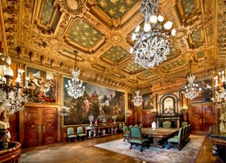 The gilded dining room at the Elms in Newport, Rhode Island, filled with ornate crystal chandeliers and oil paintings and a painted ceiling