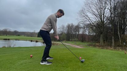 Golfer tees off on a course