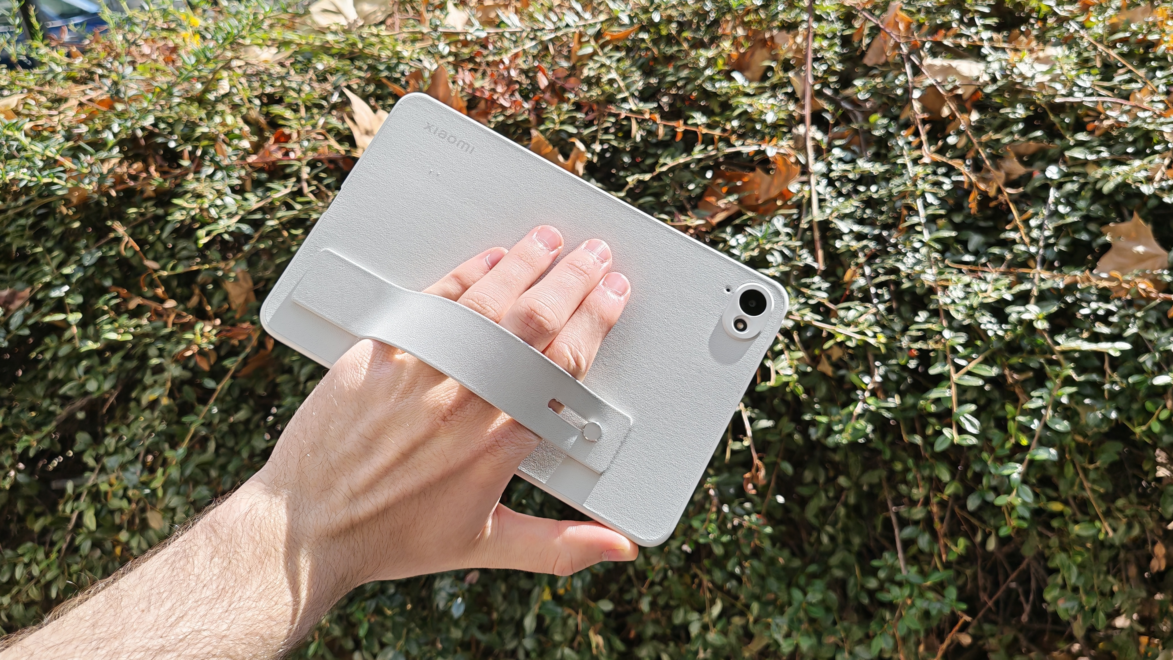 Xiaomi Pad Mini, rear cover visible, greenery in background