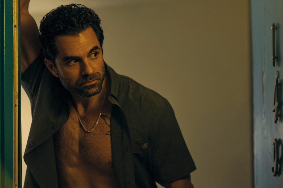Gerardo Celasco as DEA Agent Marcus Sanchez with his shirt unbuttoned leaning against a wall