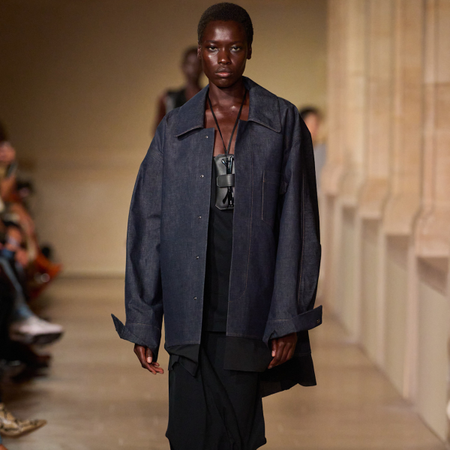 A Victoria Beckham runway model wearing a denim shacket. 