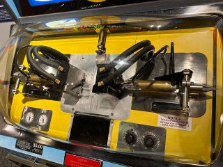 A closer look at the Mold-A-Rama mechanism and metal mold used to make the plastic space shuttle over Earth toy models.