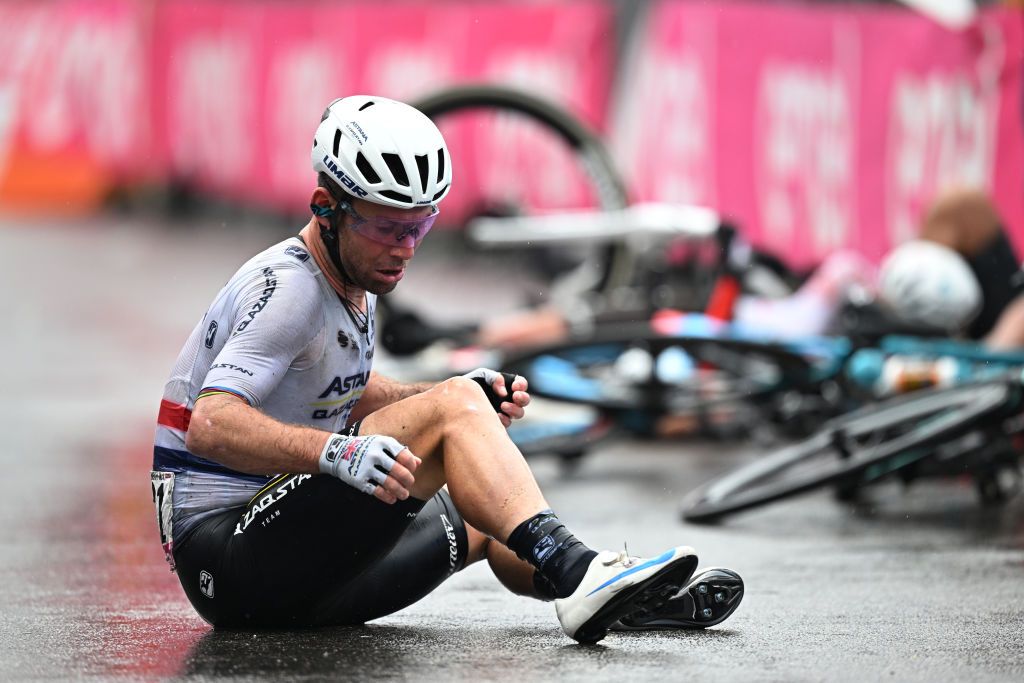 Mark Cavendish checks his injuries after the sprint crash in Salerno