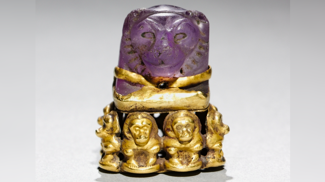 Lion's head pendant: An ancient Egyptian board game piece that was later repurposed into a magical religious object with baboons