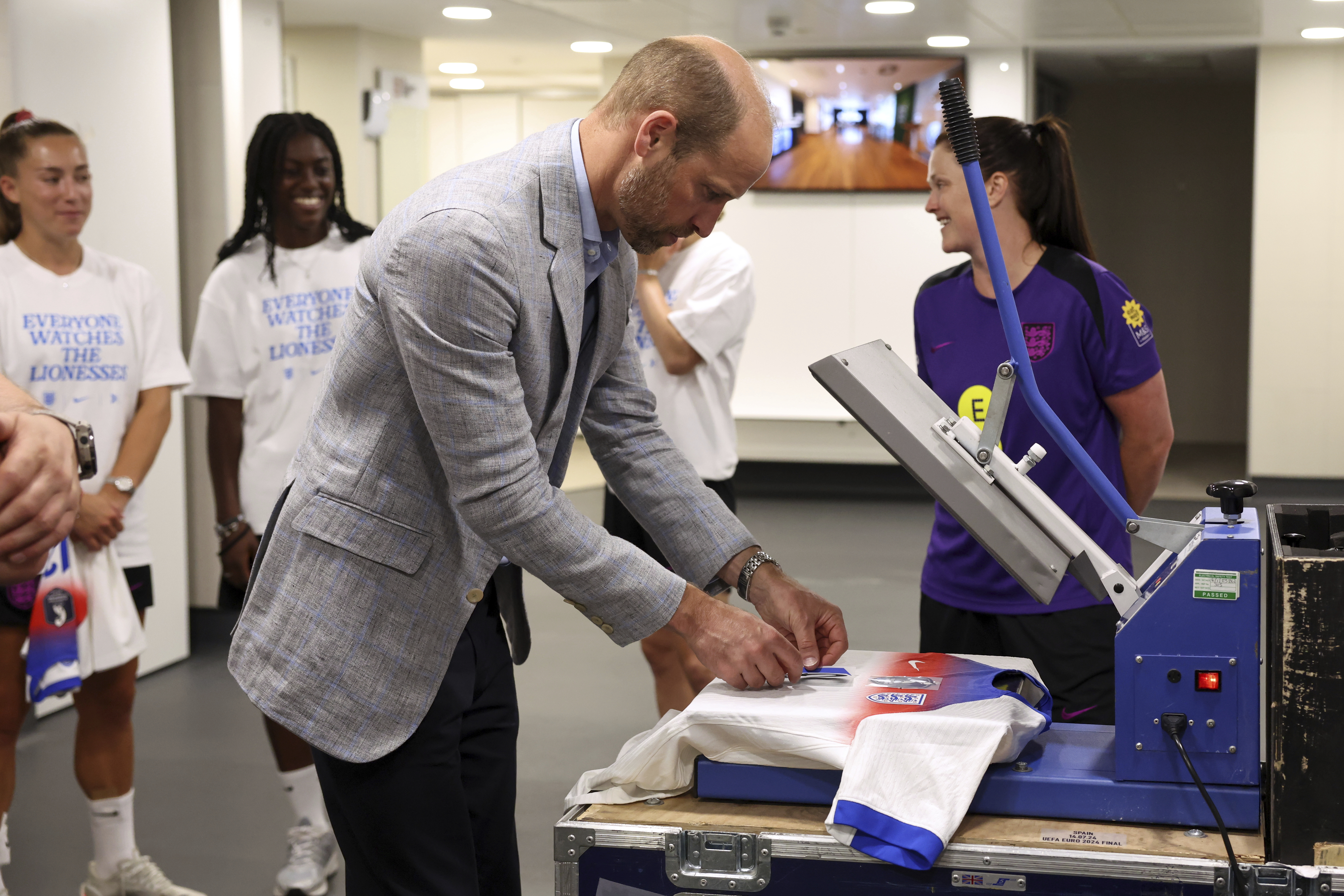 Prince William printing a football shirt during a visit to the Lionesses squad
