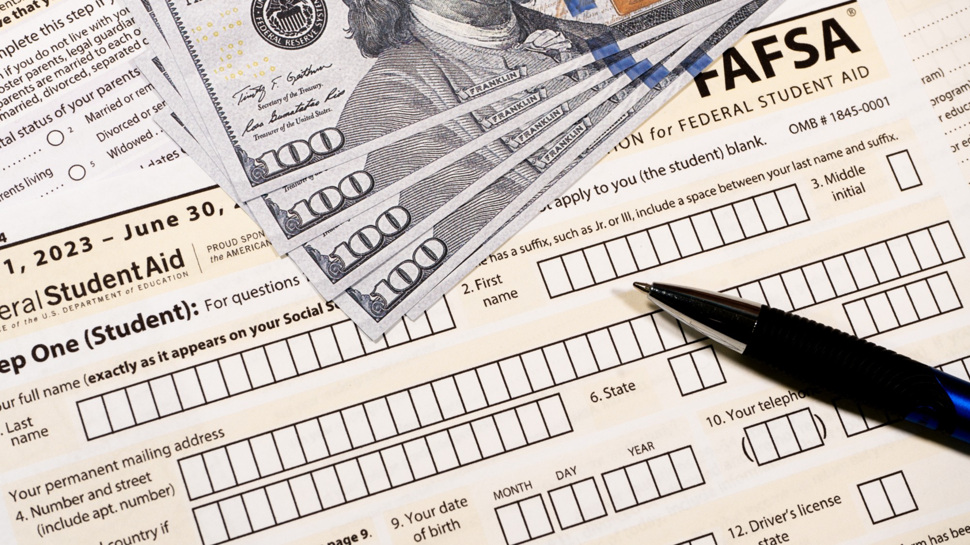 Close up of federal financial aid application with US cash