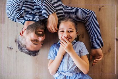 Best dad jokes: Father and daughter laying on the floor and the daughter is laughing