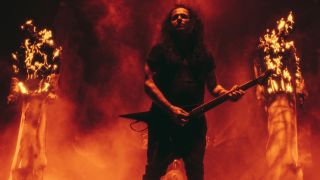Mille Petrozza of Kreator onstage with two burning wicker men