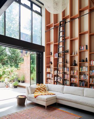A living room with built in storage till the ceiling