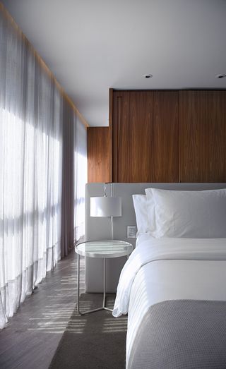 Bedroom with white pillow table lamp and white curtains