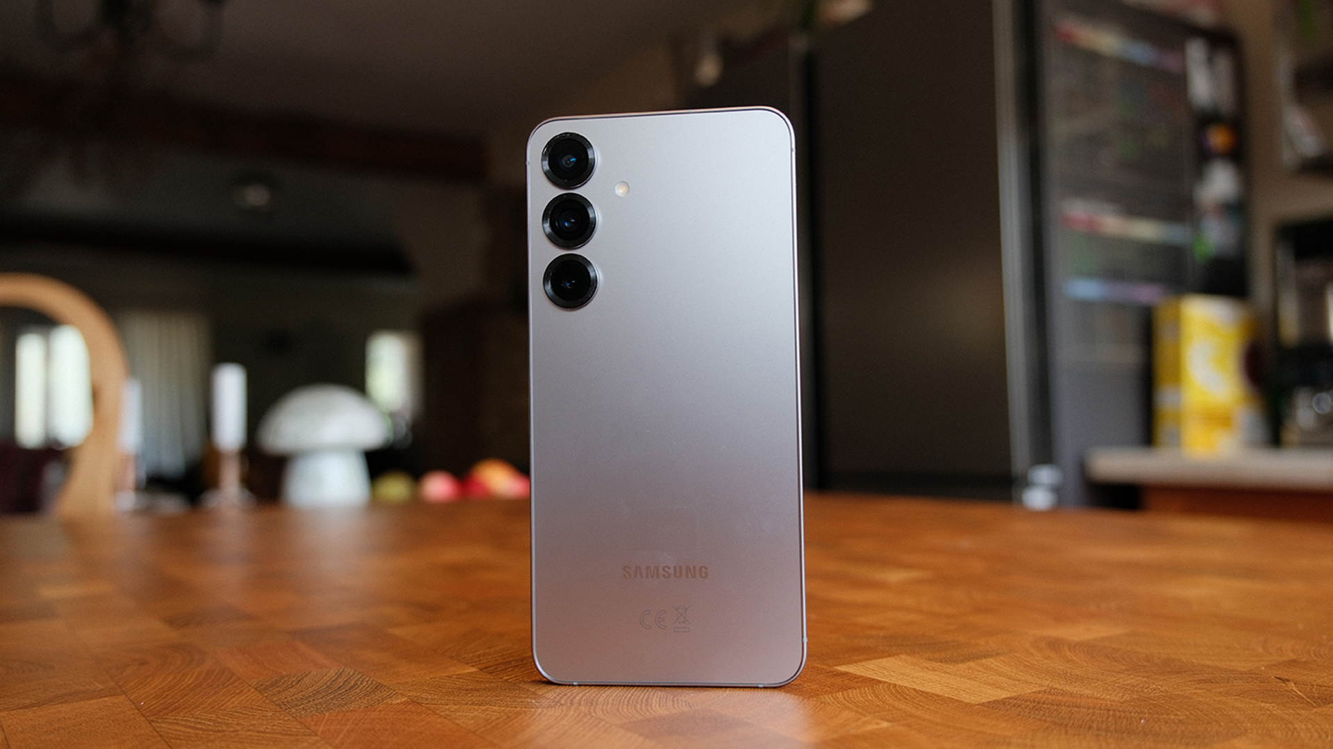 Samsung Galaxy S25 Plus smartphone stood up on wooden table, showing rear of phone