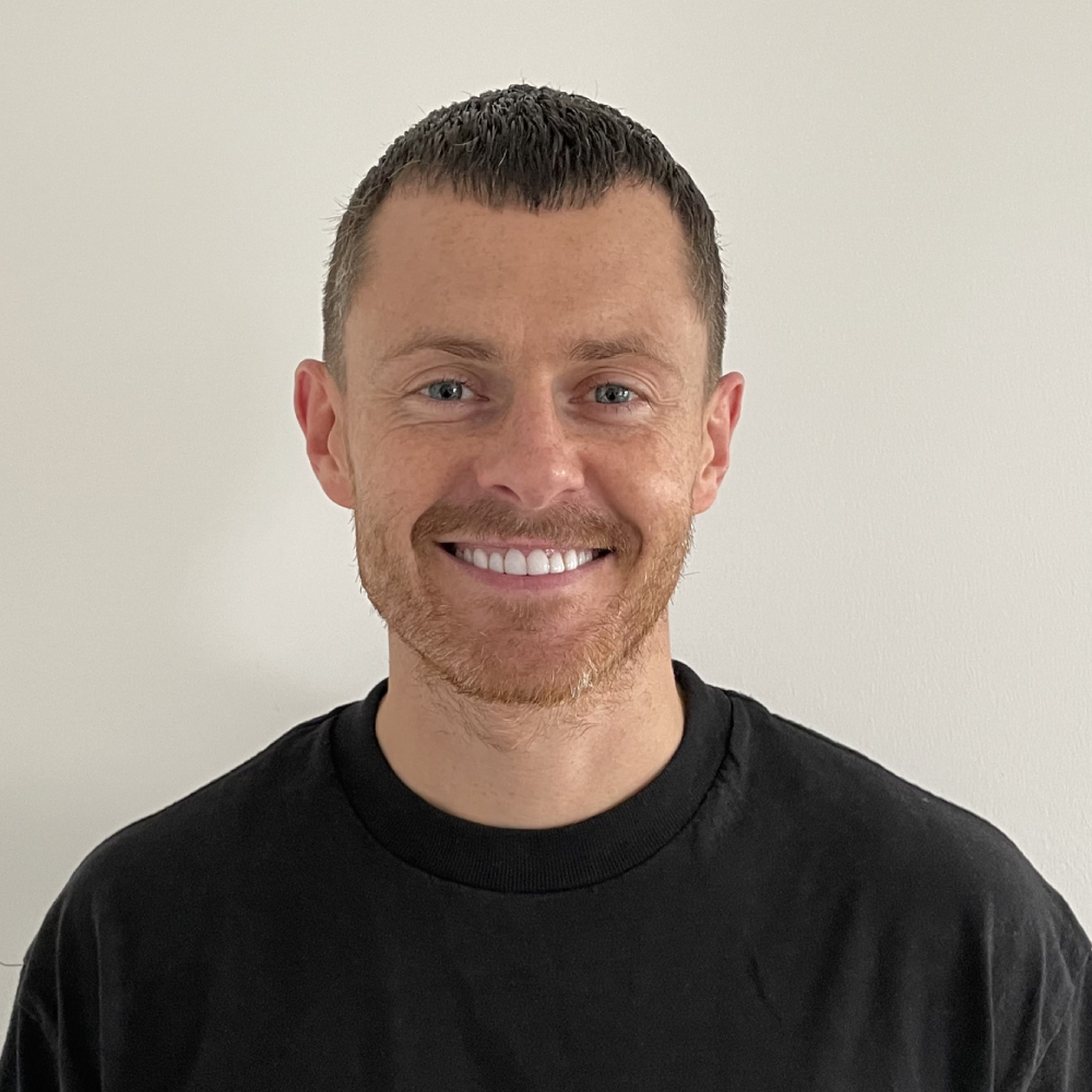 male with short hair, facial hair, wearing black t-shirt