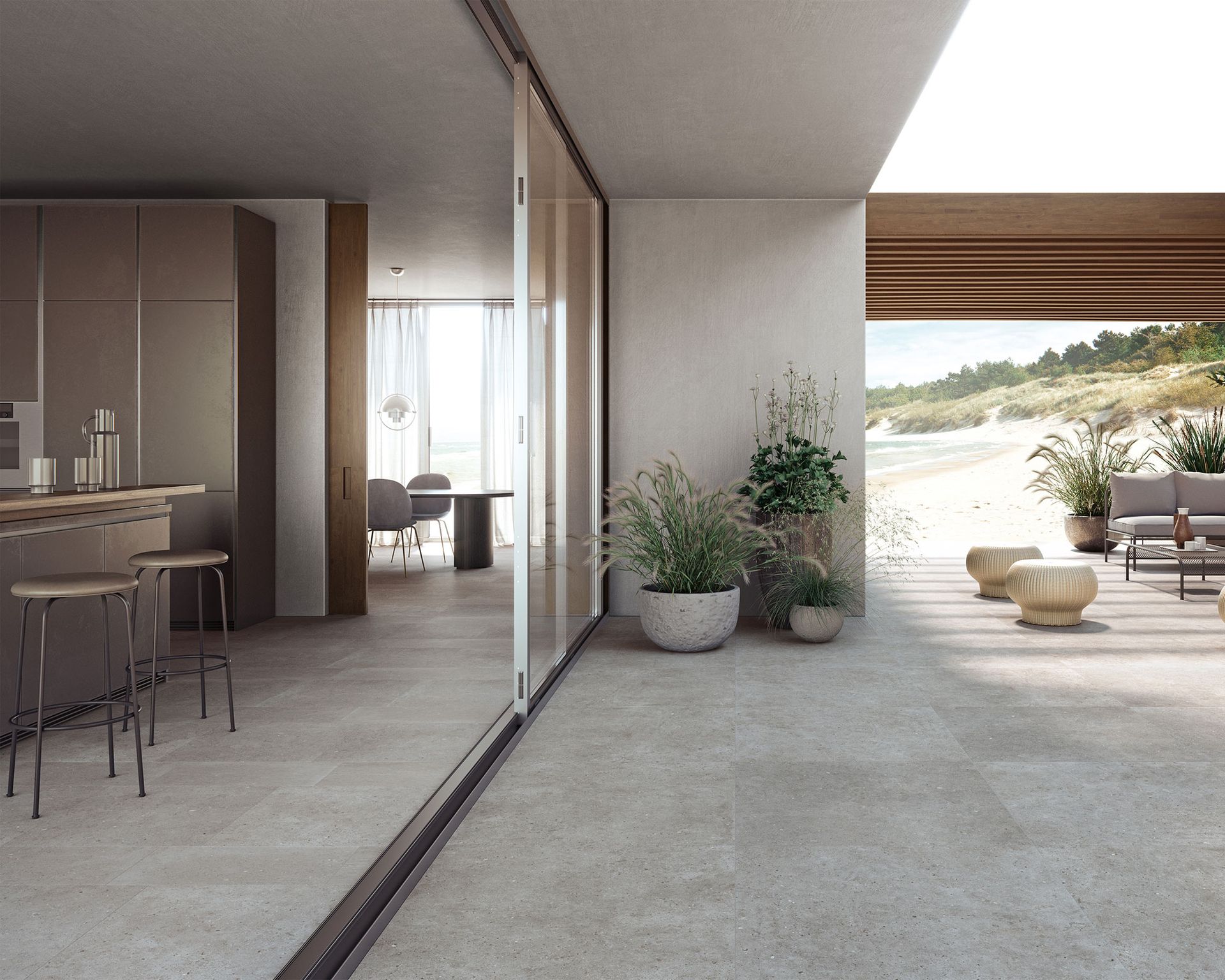 Modern home, indoor-outdoor shot of open plan kitchen, leading out onto patio, same gray tiles inside and out