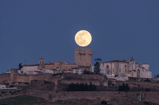 full moon aligned with a tower on a portuguese castle
