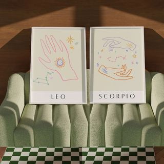 Etsy astrology posters on a green sofa