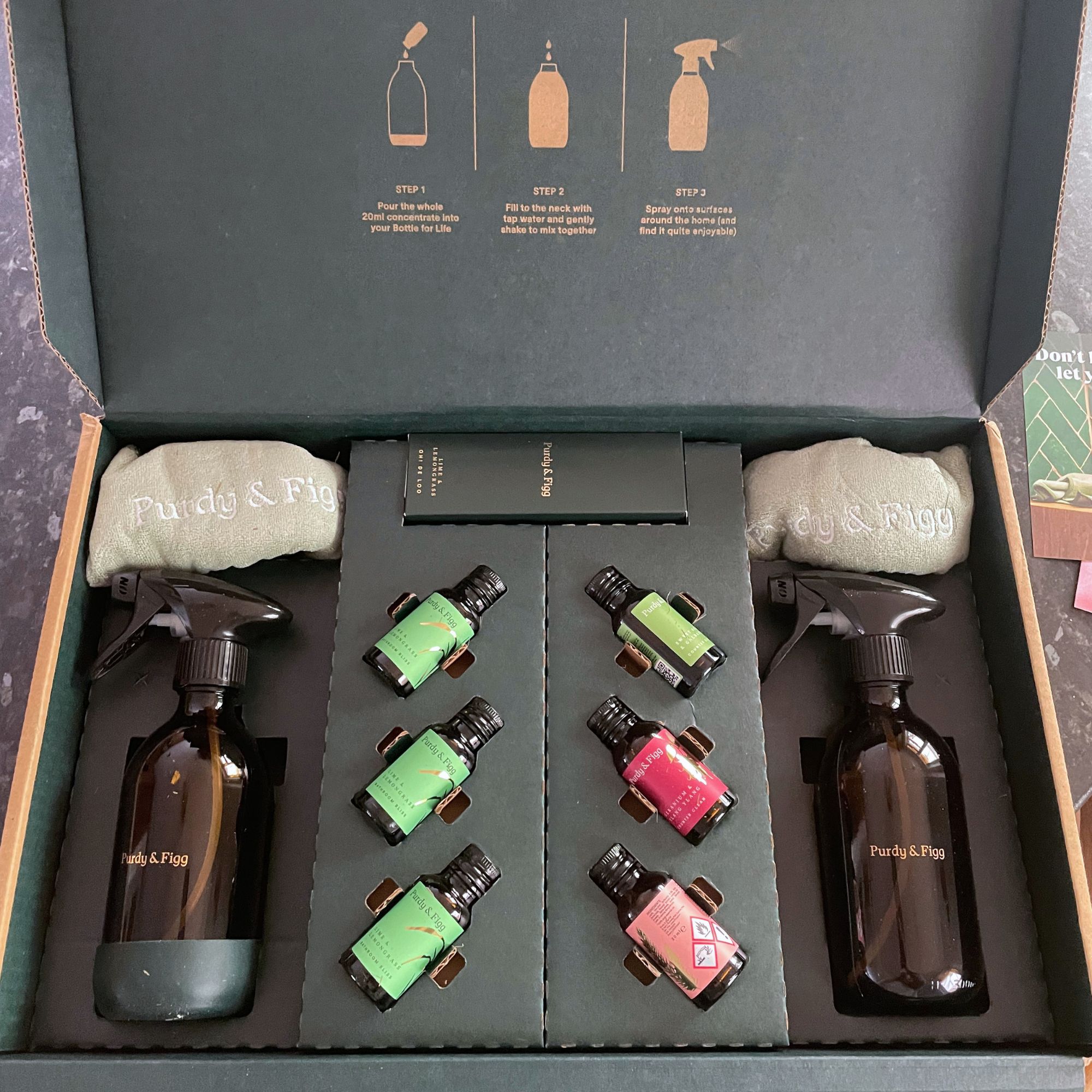 Purdy &amp;amp; Figg cleaning products, glass bottles and cleaning cloths in the original packaging with the lid open