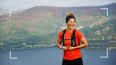 Sabrina Pace Humphreys standing on a summit with lake view behind her, smiling 