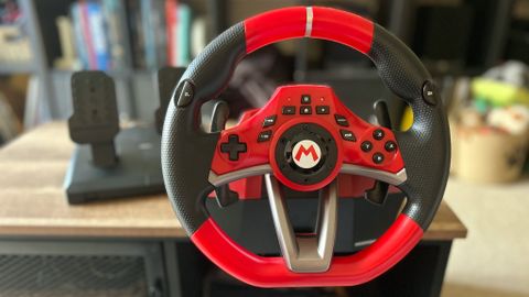 Hori Mario Kart Racing Wheel Pro Deluxe racing wheel attached to a wooden table