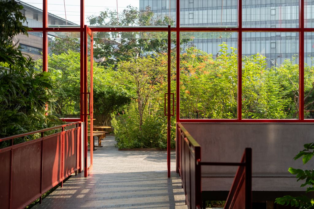 Red structure opening up into a green garden