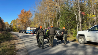 Maine rangers stretcher carry a patient to an ambulance