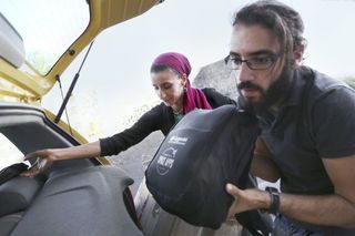 Man putting aid packs into car