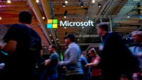 Attendees pictured walking past the Microsoft logo at Web Summit 2019 in Lisbon, Portugal.