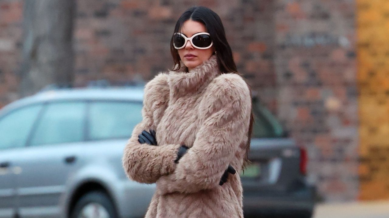 Kendall Jenner wearing a fur coat and a pair of white bug eye sunglasses