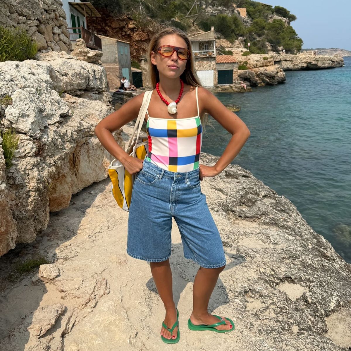 rita montezuma wearing flip flops, denim shorts and a swimming costume