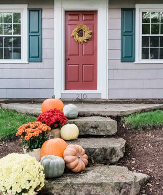rock stepping stone path with pumpkins leading to door