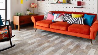 pale wood effect vinyl flooring in living room with orange sofa