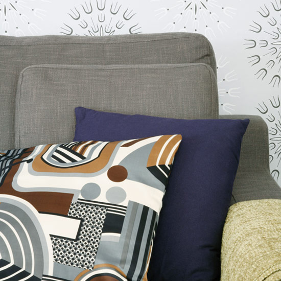 Cushions with wallpaper on wall and armchair