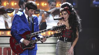 UNITED KINGDOM - FEBRUARY 20: EARLS COURT Photo of Mark RONSON and Amy WINEHOUSE, Mark Ronson performing on stage with Amy Winehouse, twin necked guitar (Photo by JMEnternational/Redferns)