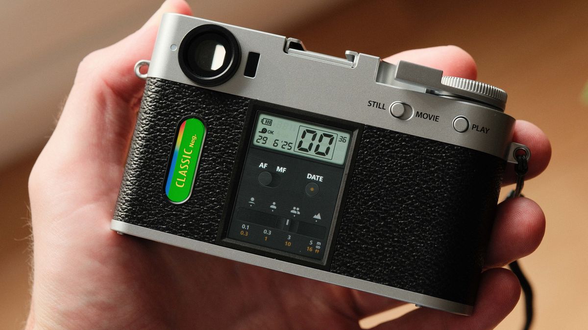 Fujifilm X Half camera held in a hand showing the film camera mode