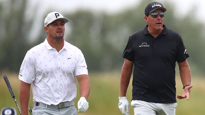 Bryson DeChambeau and Phil Mickelson walk on a golf course