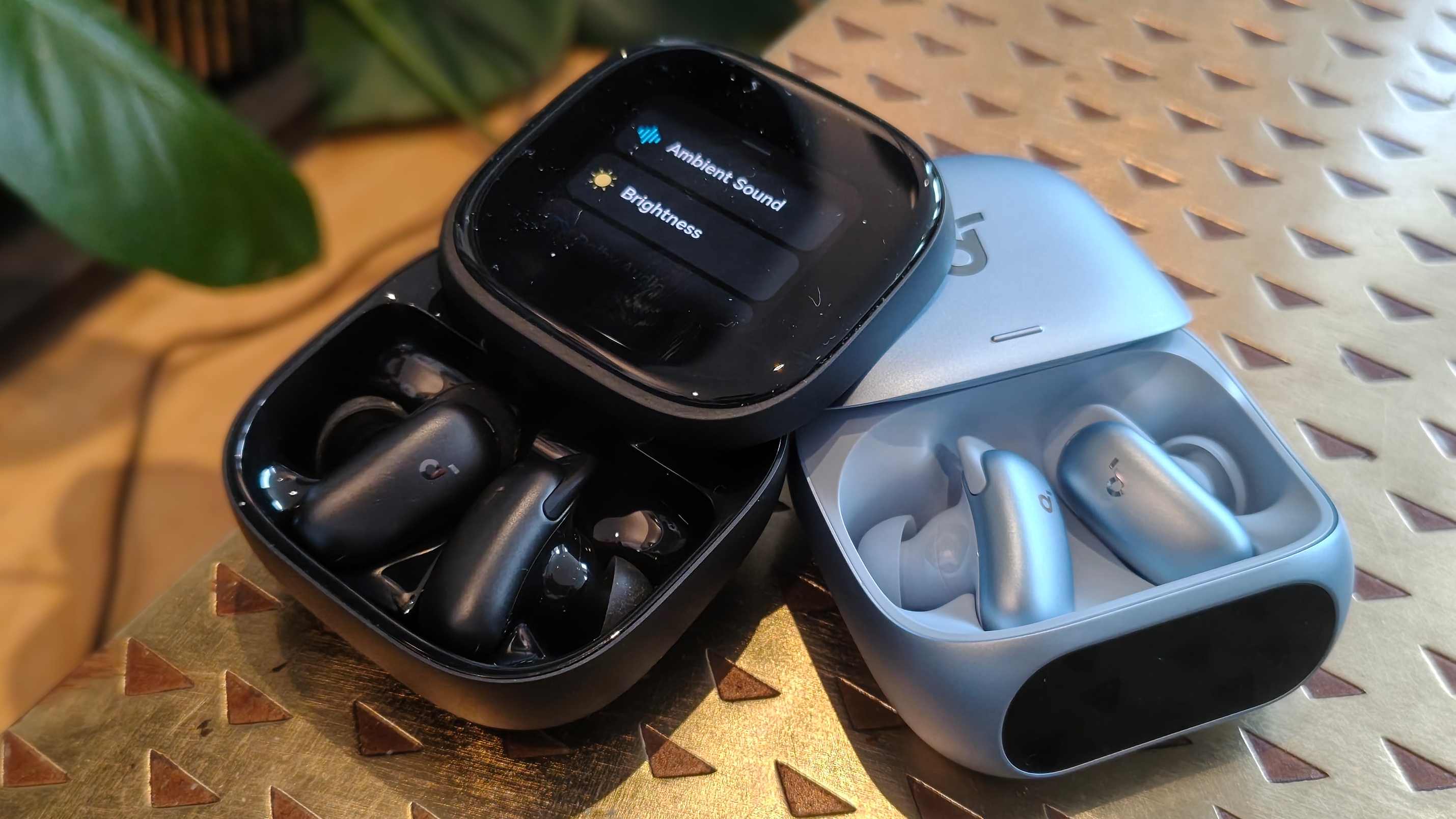 The Anker Soundcore Liberty 5 Pro and Anker Soundcore Liberty 5 Pro Max on a bronze table.