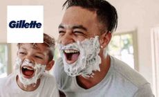 Gillette Logo placed over an image of a father and son smiling with shaving cream on their faces