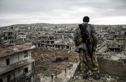 A marksman looks out over a destroyed Syrian city