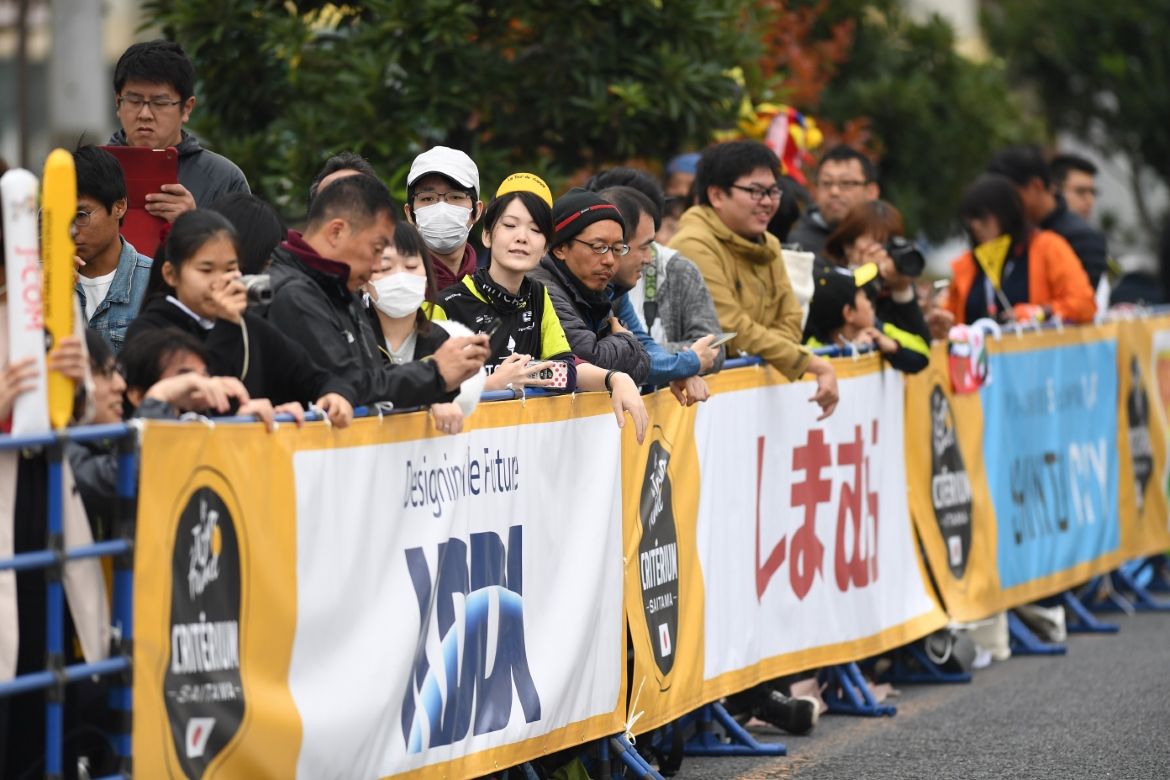 Fans watch on the side of the road