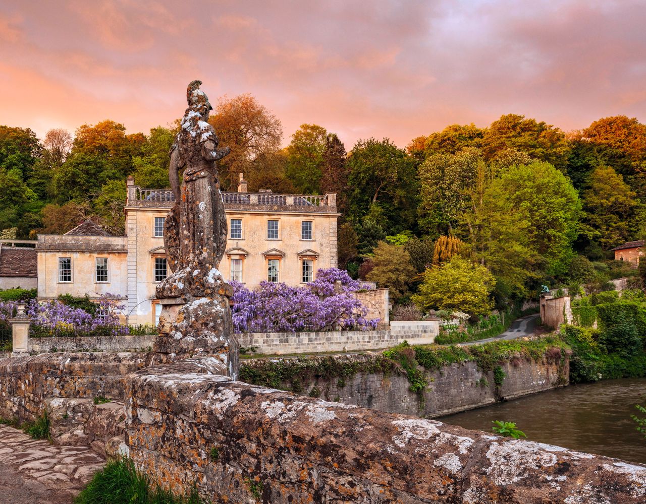 The bridge over the River Frome, which was built in about 1400, with the 18th century statue of Britannia, originally from Dorset, placed here by Harold Peto.