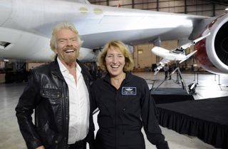 Virgin Galactic founder Sir Richard Branson and pilot Kelly Latimer pose for a photo during the Dec. 3 unveiling of the company's Cosmic Girl jet, a carrier plane for its LauncherOne rocket.