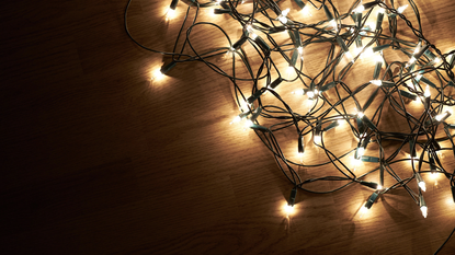 A string of christmas lights in a ball on a table, turned on 