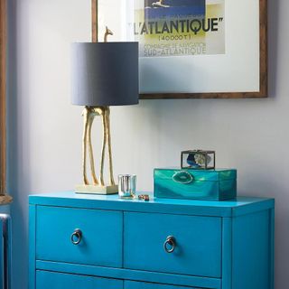turquoise vanity with giraffe lamp and blue box