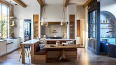 large kitchen with L-shape island and banquette seating/dining