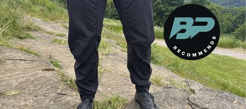 Man wearing Mons Royale Virage Pants with countryside backdrop
