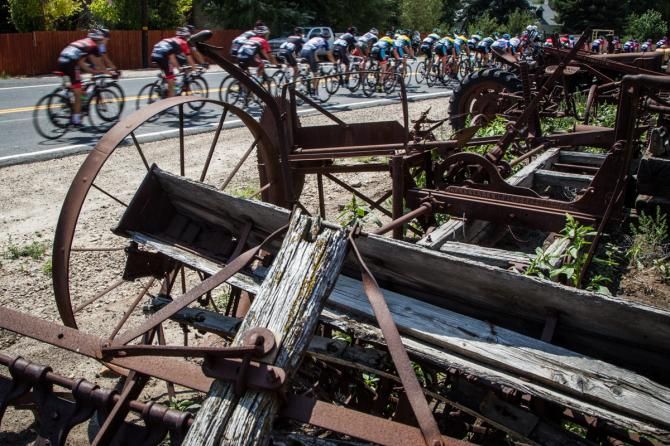 The peloton passes by farm equipment align todays route.