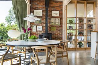 dining area with stove, brick wall and glass and timber partition