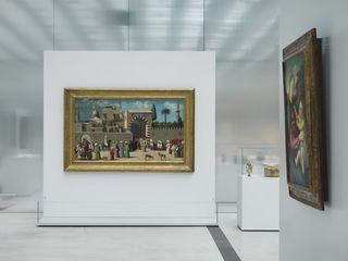 Two framed paintings hang against white backdrops