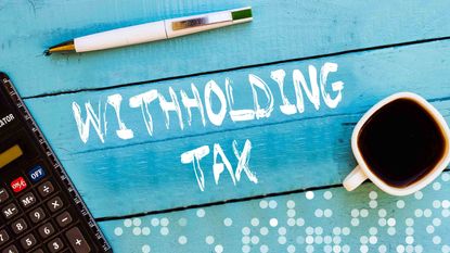 Picture of "withholding tax" written on blue wood