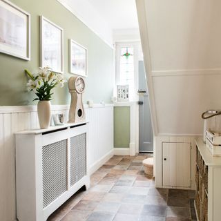 A hallway with a staircase and a radiator cover on a radiator